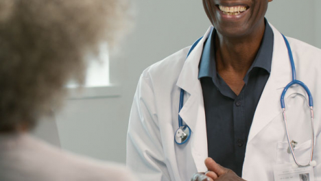 Mid-Section-Smiling-Doctor-Talking-to-Patient